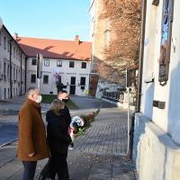 Wicestarosta Paweł Osikowski z c&oacute;rką i Przewodniczący Krzysztof Świerczek składają wiązankę pod tablicą poświęconą Marszałkowi Piłsudskiemu