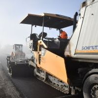 Układanie asfaltu na drodze powiatowej w Brzuchani