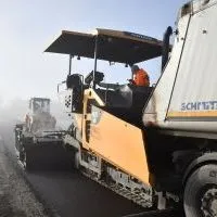Układanie asfaltu na drodze powiatowej w Brzuchani