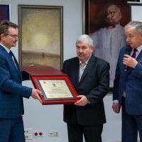 Starosta Miechowski Jacek Kobyłka i Przewodniczący Rady Powiatu Krzysztof Świerczek wręczają jubileuszowy grawer Dyrektorowi Muzeum Ziemi Miechowskiej