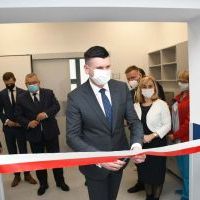 Wicemarszałek Łukasz Smółka przecina wstęgę na otwarciu Pracowni Rezonansu Magnetycznego w miechowskim szpitalu 