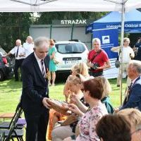 Dożynki Powiatowe Przybysławice 2023 - Piotr Grządziel z Zarządu Powiatu częstuje chlebem dożynkowym