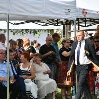 Dożynki Powiatowe Przybysławice 2023 - Wojciech Domagała z Zarządu Powiatu częstuje chlebem dożynkowym