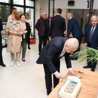 Naczelnik Roman Wąwoźny kroi tort na otwarciu nowego Wydziału Komunikacji w Miechowie