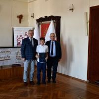 Starosta Miechowski oraz Naczelnik Wydziału Oświaty, kultury i sportu z zawodnikiem, który otrzymał stypendium