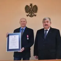 Starosta miechowski Jacek Kobyłka gratuluje Medalu za Długoletnią Służbę Zbigniewowi Bałazemu, Powiatowemu Inspektorowi Nadzoru Budowlanego w Miechowie